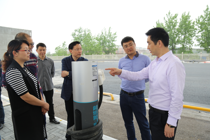 圖為公司董事長沈小平向領導一行匯報充電樁建設情況.png